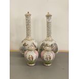 A pair of ceramic bottle neck vases, each with a cover, with gilt decoration and painted with