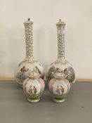 A pair of ceramic bottle neck vases, each with a cover, with gilt decoration and painted with