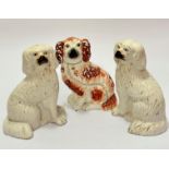 A pair of Victorian pottery moulded chimney spaniels with painted muzzles and eyes and gilt collars,