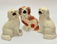 A pair of Victorian pottery moulded chimney spaniels with painted muzzles and eyes and gilt collars,