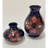 A William Moorcroft baluster pottery vase decorated with anemone design on blue ground, impressed