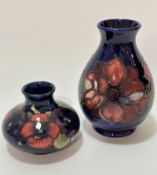 A William Moorcroft baluster pottery vase decorated with anemone design on blue ground, impressed