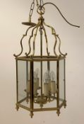 A gilt brass hall lantern of hexagonal outline, with inset glass panels enclosing six branches,