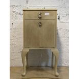 A bleached walnut bedside table, fitted with a drawer and cupboard, raised on cabriole supports,