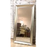 A wall mirror with bevelled plate with in a moulded silvered frame, 174cm x 86cm