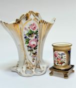 An early 19thc china cylinder spill vase raised on scroll feet decorated with rose and floral panels