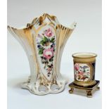 An early 19thc china cylinder spill vase raised on scroll feet decorated with rose and floral panels