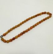 A 1920s amber oval necklace with yellow yolk coloured beads, (L 19cm) (16.35g)