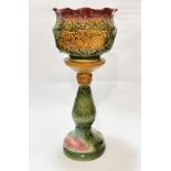 A Victorian style pottery moulded jardiniere and stand with flared rim, decorated with sea serpent