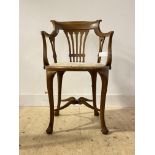 An early 20th century mahogany desk chair, with open back and arms, upholstered circular seat,