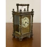 A late 19th/ early 20th century brass four glass carriage time piece clock, the case with swing