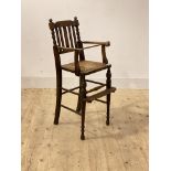 An early to mid 19th century stained beech childs highchair, with rail and bobbin turned back rest