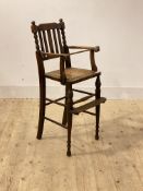 An early to mid 19th century stained beech childs highchair, with rail and bobbin turned back rest