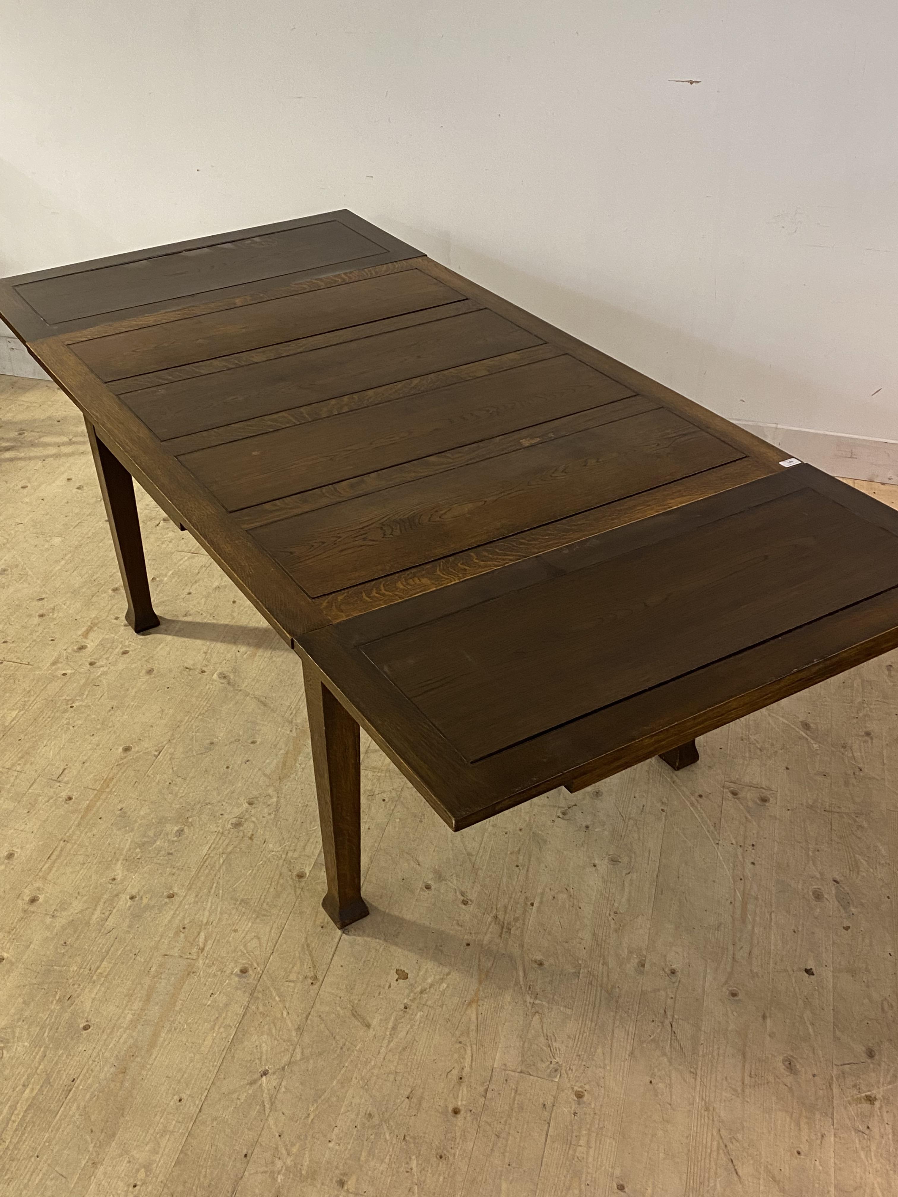 An oak Arts and Crafts duo drawer leaf dining table, the panelled rectangular top raised on square - Image 2 of 3