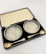 A pair of crystal slice cut condiment dishes complete with pair of Epns gilt spoons, in original