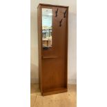 A mid century teak hall cupboard, the front with mirror (A/F) three hooks and an open shelf, with