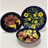 A Moorcroft dish decorated with cowslips design on blue ground, (d 12cm) impressed mark verso and