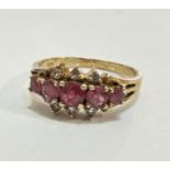 A yellow metal five stone graduated ruby and six stone white sapphire ring mounted in claw