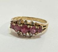 A yellow metal five stone graduated ruby and six stone white sapphire ring mounted in claw