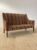 A contemporary high back settee or sofa, upholstered in poly chromatic cut velvet, raised on