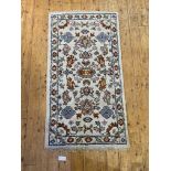 An Indian hand knotted rug, the ivory ground of stylised floral design, 156cm x 81cm