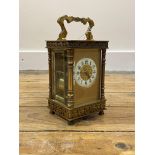 A Late 19th/ early 20th century gilt brass carriage clock, the four glass case with swing handle