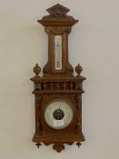 A late 19th century oak wall hanging aneroid barometer and thermometer with ivorine registers H54cm