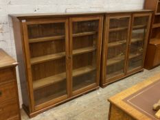A pair of early 20th century pine glazed bookcases, each with two doors enclosing three adjustable