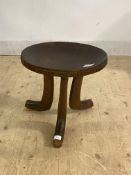 An African Carved hardwood stool, the dished top raised on triple splay supports, H38cm, D40cm