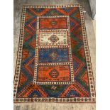 A hand knotted Turkish / Caucasian carpet, the field of blues, reds and greens with four panels