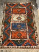 A hand knotted Turkish / Caucasian carpet, the field of blues, reds and greens with four panels