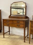 A 20th century mahogany dressing table, the bevelled swing mirror over three trinket drawers, two