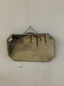 An Art Deco period frameless bevelled wall mirror with cast metal stylised surmount 67cm x 41cm