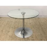 A contemporary dining table, the circular glass top raised on a chrome base H77cm, D100cm