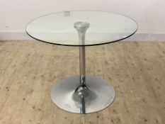 A contemporary dining table, the circular glass top raised on a chrome base H77cm, D100cm
