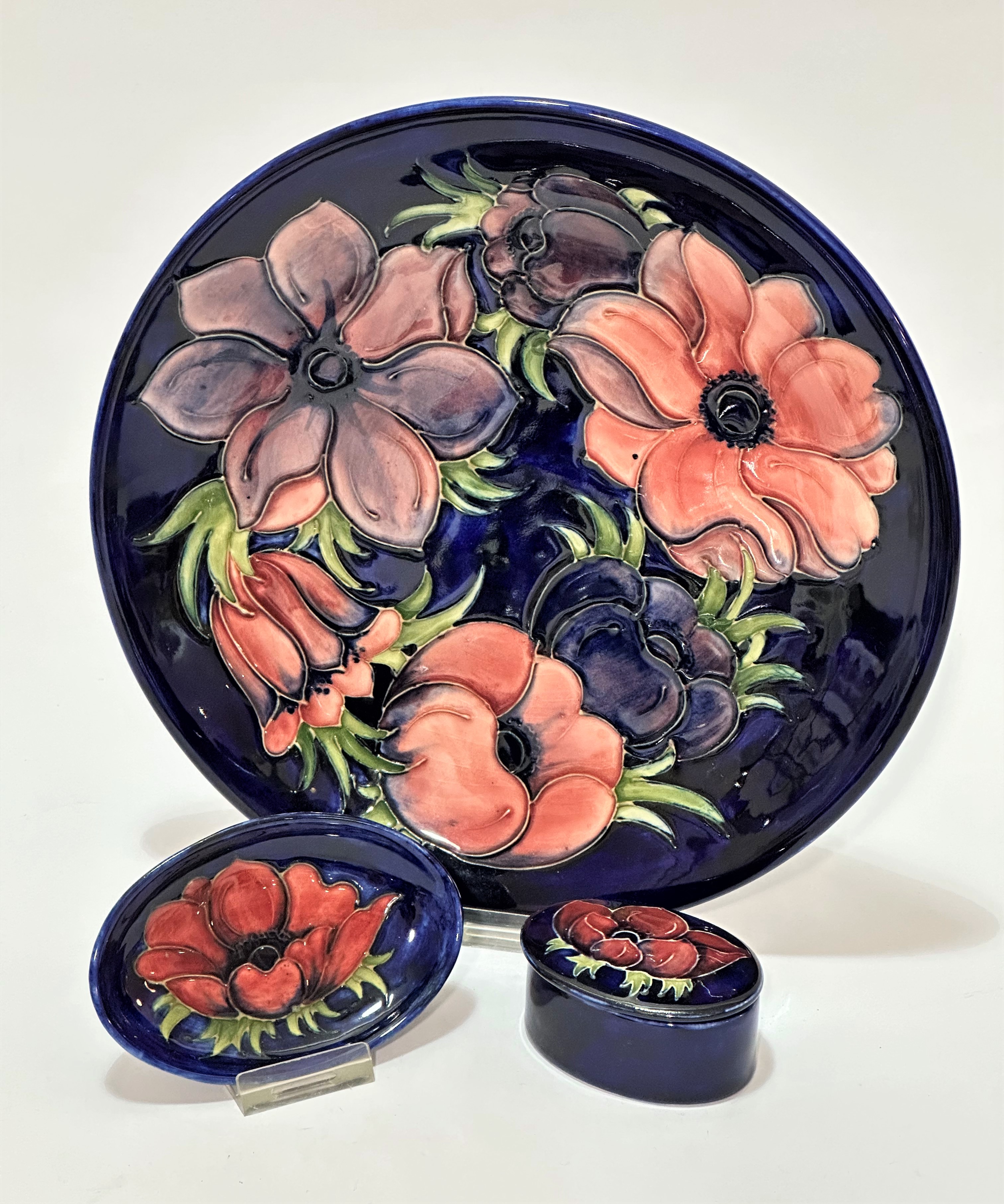 A William Moorcroft circular dish decorated with anemone design with blue ground (d 26cm), impressed
