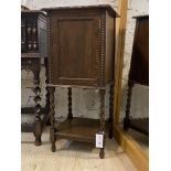 A 1930s oak bedside cupboard with single drawer, spiral turned supports and under tier (door