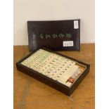 An early to mid 20th century Chinese resin mahjong set in a stained hardwood case, L27cm