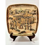 A Japanese Satsuma square shaped dish decorated with a procession of female courtiers with pagodas