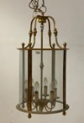 A gilt lacquered brass hall lantern of cylindrical form, the case suspended from four scrolled