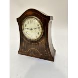 An Edwardian mahogany arched mantel clock with box wood strung and inlaid front with enamelled
