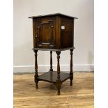 An early 20th century oak bedside cupboard, fitted with one geometric panelled door, raised on