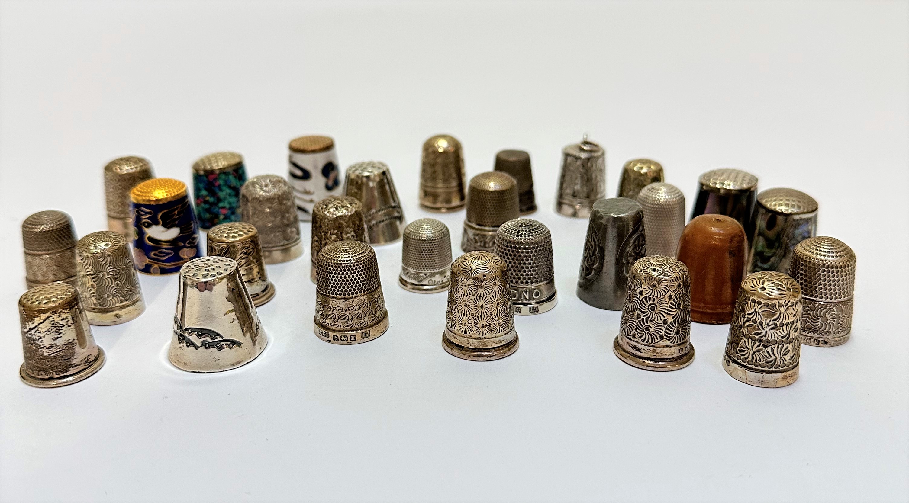 A collection of twenty one various engraved thimbles, some with floral design, engine turned