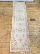 An Indian washed wool runner rug, the ivory field with floral motif and bordered 360cm x 95cm