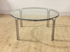 A post modern coffee table, the circular glass top raised on chromium plated tubular supports,