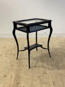 An Edwardian ebonised bijouterie table, the serpentine moulded top over glazed frieze and slender