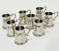 A set of eight English pewter baluster form tankards with C scroll handles to side, two slight dents