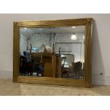 A gilt framed wall hanging mirror, reeded frame with bullseye to each corner enclosing a bevelled