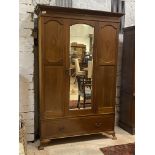 An Edwardian inlaid mahogany wardrobe, the projecting cornice over bevel glazed mirror door