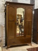 An Edwardian inlaid mahogany wardrobe, the projecting cornice over bevel glazed mirror door